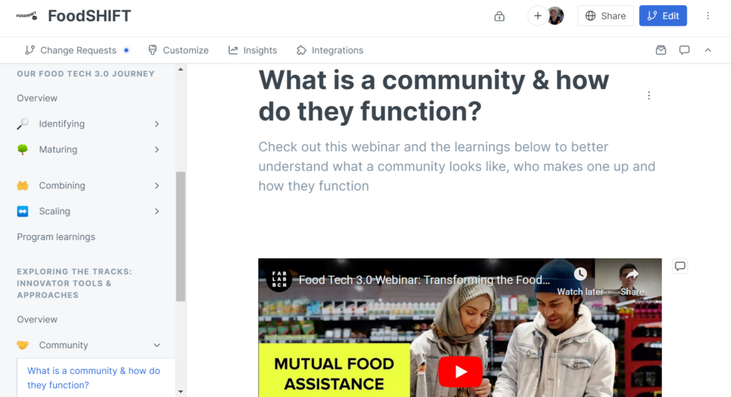 A screenshot of the Food Tech 3.0 GitBook webpage is open to the community sub-section titled, “What is a community & how do they function.” It includes a still of Food Tech 3.0’s recent webinar on Transforming the Food System from Communities in which two people are interacting around food next to the title ‘Mutual Food Assistance’]